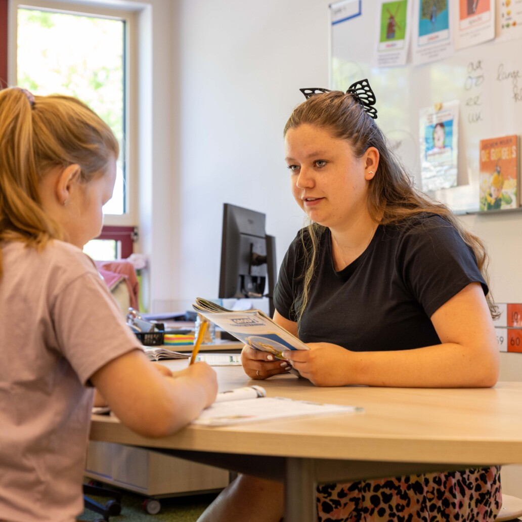 Een onderwijsassistent werkt met een leerling